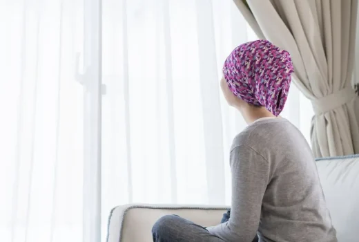 Young woman with head scarf looking out window