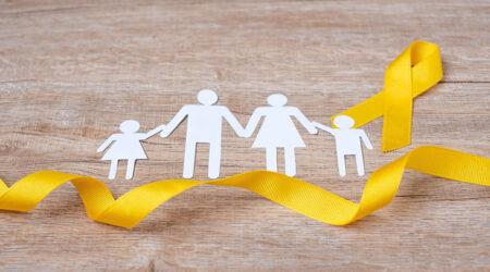 Paper cut out of family figures with a yellow ribbon