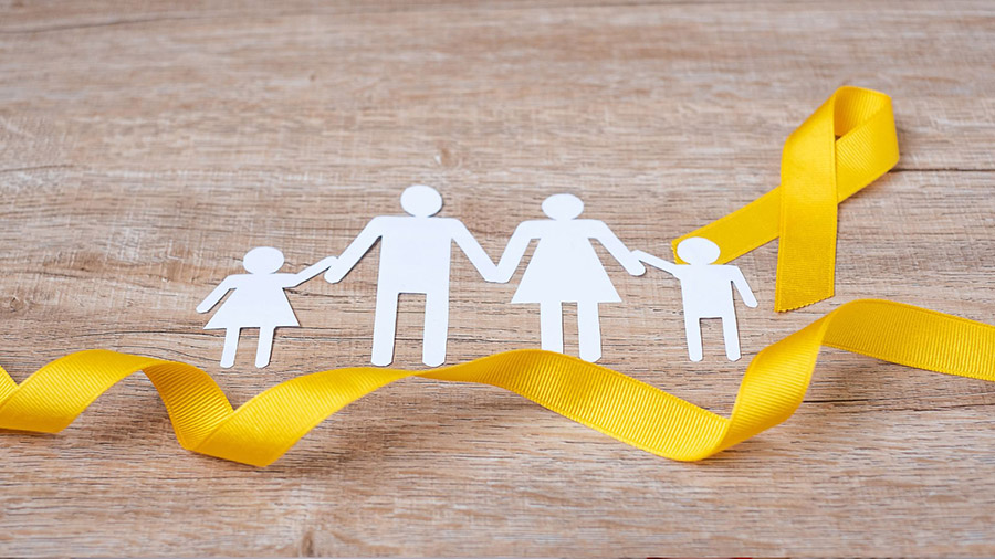 Paper cut out of family figures with a yellow ribbon