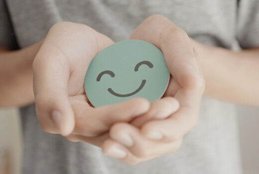 Person holding circle with smiling face