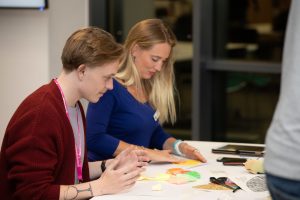 One man and one woman in their 20s engage in a craft project around brain health
